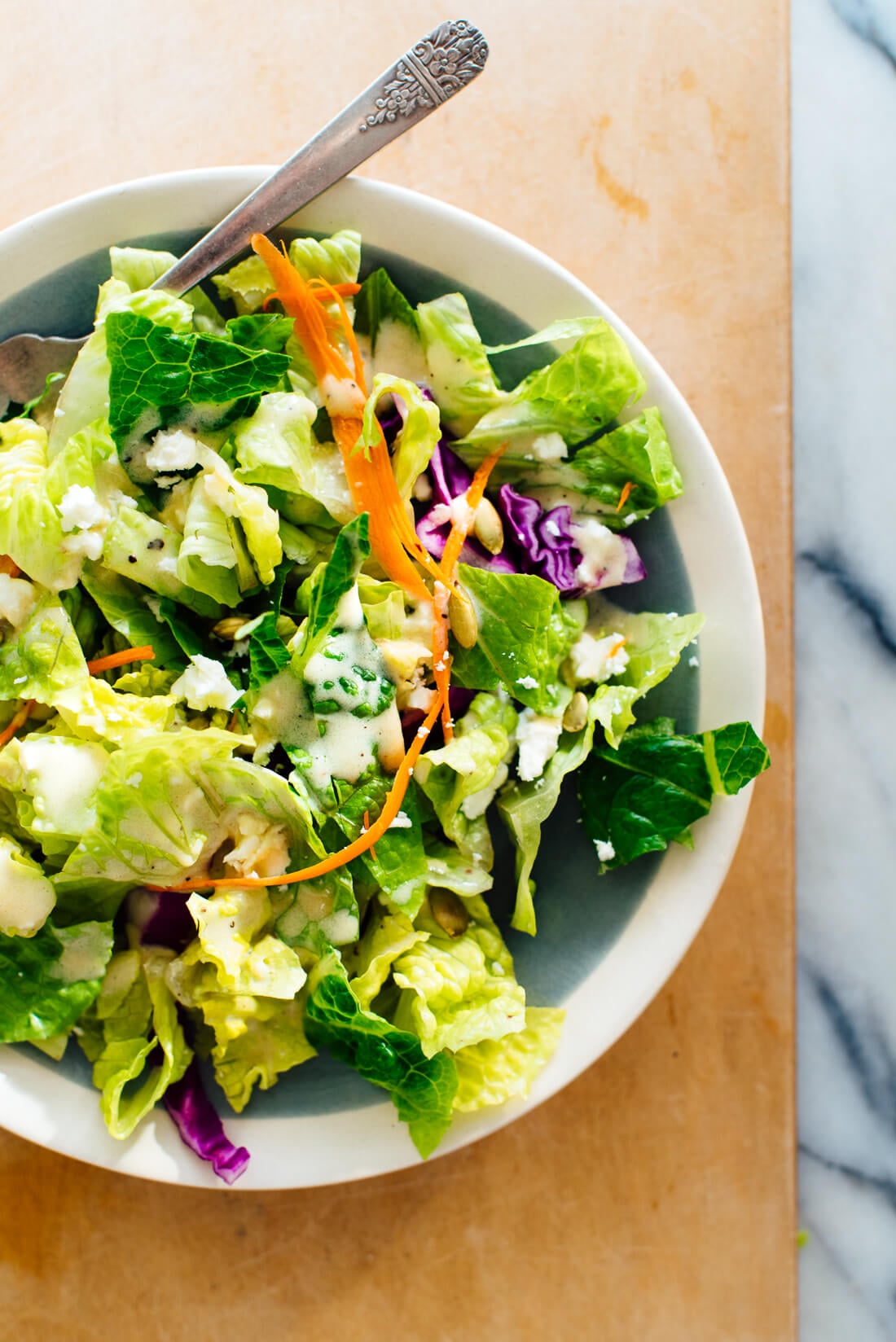 green salad with honey-mustard dressing drizzled on top